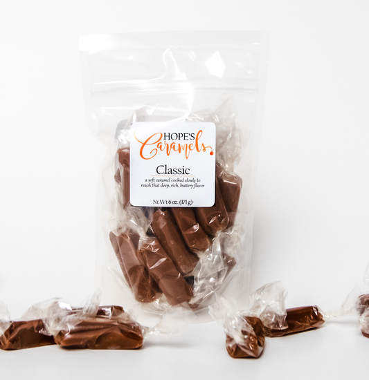 Clear bag filled with classic caramels and caramels scattered around bag